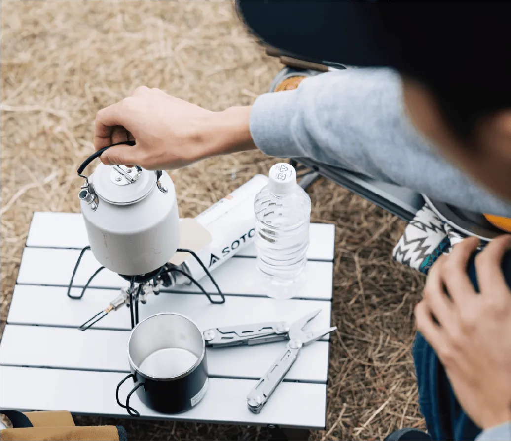 キャンプテーブルでお湯を注ぐシーン